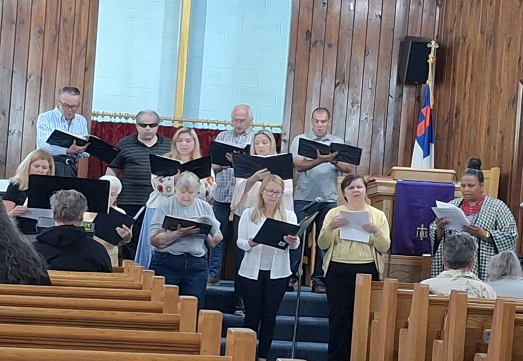 Church choir standing at the front, singing hymns during a worship service.