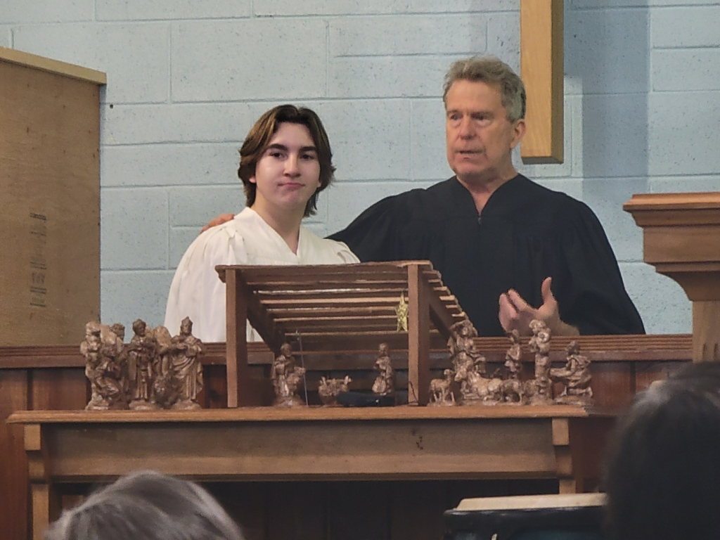 Church baptism moment with a pastor standing beside a young person at the altar.